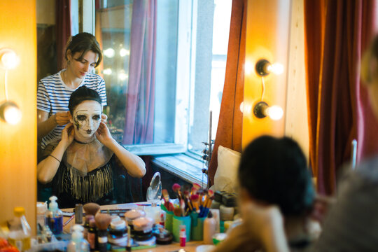 An actress and a make-up artist in front of a mirror