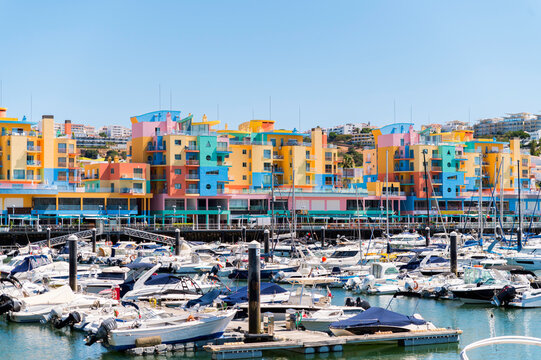 Boats moored in harbor near colorful buildings in Albufeira