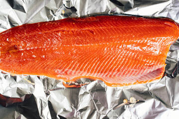 orange salmon filet on foil ready to grill