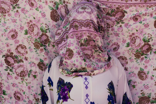 Abstract portrait of a young woman wearing colorful fabric on her face