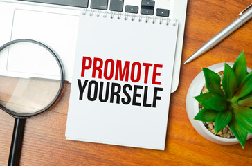 PROMOTE YOURSELF writing text post it paper in office on laptop computer keyboard