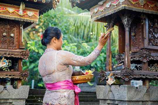 Woman wearing traditional clothes praying at the temple