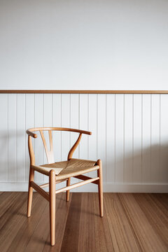 Minimalist wooden chair against blank wall