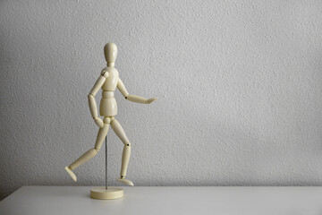 Wooden mannequin  in walking position standing on a white background