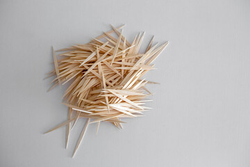 Many wooden toothpicks on a white table, top view