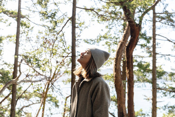 Young woman forest bathing/relaxing in forest