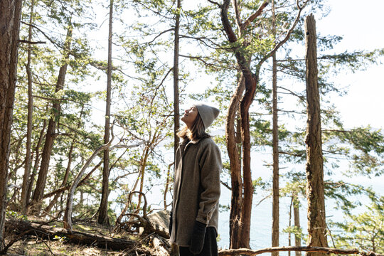 Young woman forest bathing/relaxing in forest