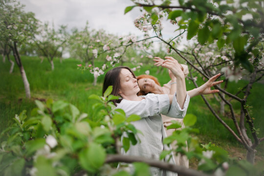 two women contemporary dancers dancing in a blossom garden
