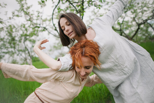two women contemporary dancers dancing in a blossom garden