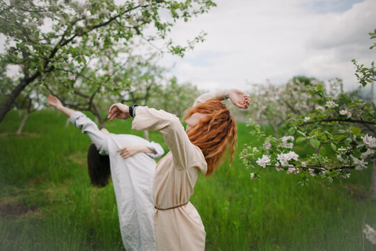 two women contemporary dancers dancing in a blossom garden