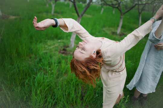 two women contemporary dancers dancing in a blossom garden