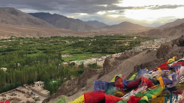 Buddhist flags flutter in the wind at monastery on  mountain overlooking the Tibetan Indian city of Leh