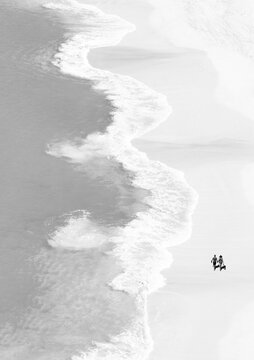 Fototapeta Drone photography with lonely couple walking on the beach
