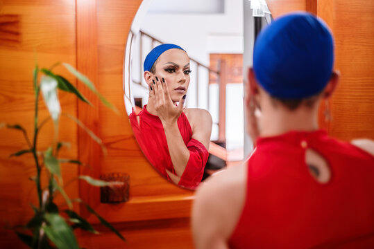 Gay man dressed as a woman looking at himself in the mirror