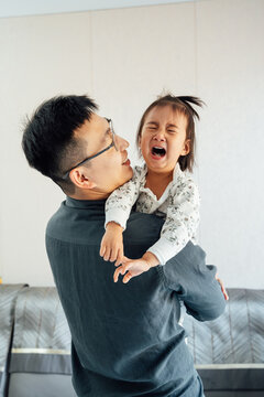 Father holding crying little girl