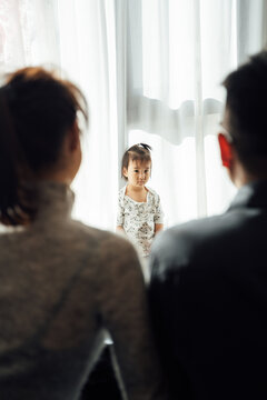 Cute baby girl and her parents at home