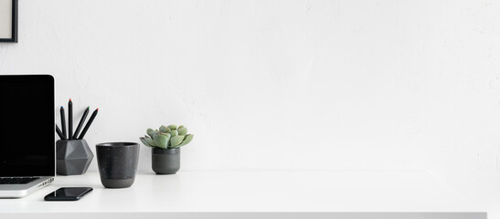Office desk with laptop mobile and coffee mug. Design workspace. Simple elements. Empty space.