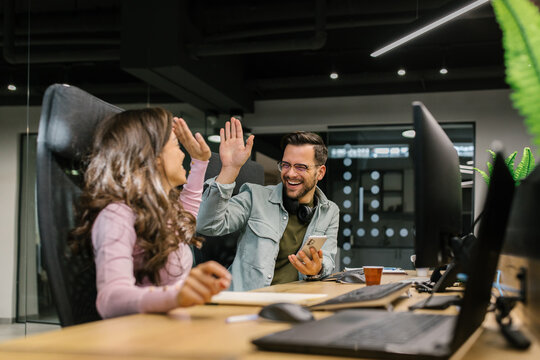 Colleagues High Fiving In The Office