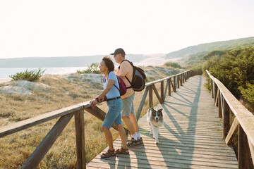 Couple looking at the sea with their dog