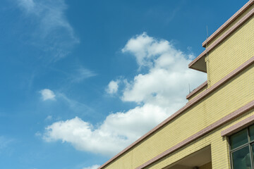 White clouds floating on the roof of the building in summer. Sunny day, sea of clouds, sky and weather material. Landcape of Dongguan, China. 
