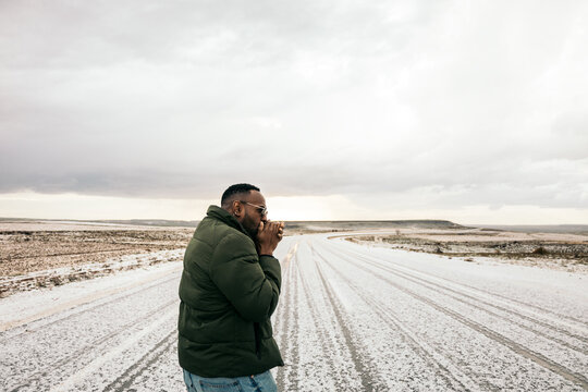 Stylish man walking on a snowy road