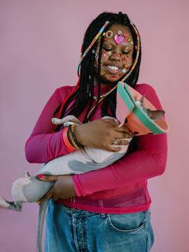 Plus size braided girl holding hairless cat in a collar