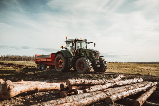 Fototapeta tractor on a farm with logs