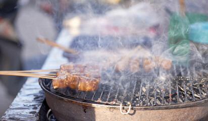 Indonesian food - Grilled meatballs ( Bakso Bakar) grilling outdoors on a barbaecue grill.