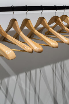 Light wood hangers on clothes rail indoors
