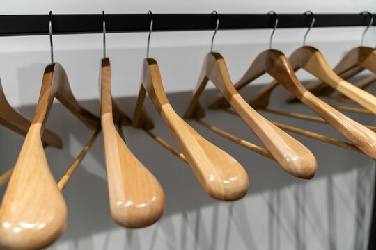 Light wood hangers on clothes rail indoors