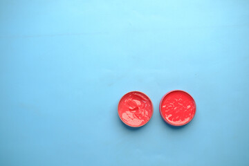top view of used petroleum jelly in a container on blue background 