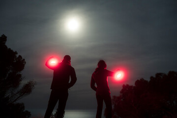 Couple silhouettes exploring the night under the moon
