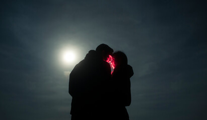 Dreamlike portrait of couple kissing under the moon