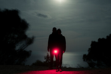 Surreal silhouettes exploring nature at night with red light