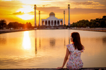 Fototapeta na wymiar Beautiful girl watching on Landscape of beautiful sunset sky at Central Mosque in Songkhla province, Southern of Thailand.
