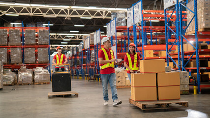 Male and female warehouse workers Working at a distribution center, standing, talking, at a large warehouse. New arrivals of additional items in the warehouse department. Employees who organize the di