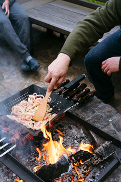 Faceless family cooking outdoors.