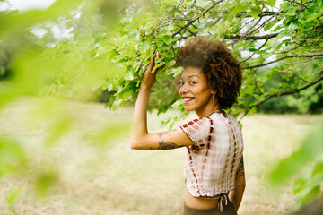 A confident woman stands in nature