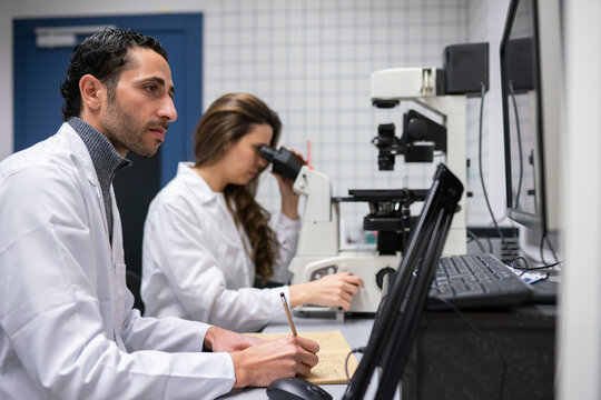 Researchers Working In Microbiology Lab Room