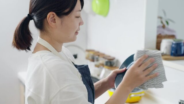 60p　キッチンで皿を拭く女性（家事・主婦）