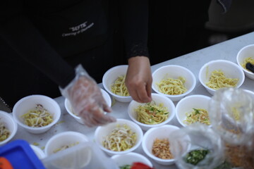 female chefs mix noodles