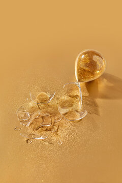 Hourglass with golden sand broken into small pieces