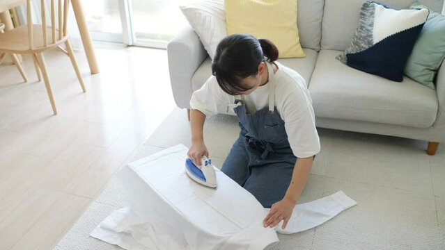 60p　アイロンかけをする女性（家事・主婦・服）