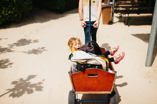 Little girl in a handcart outdoors