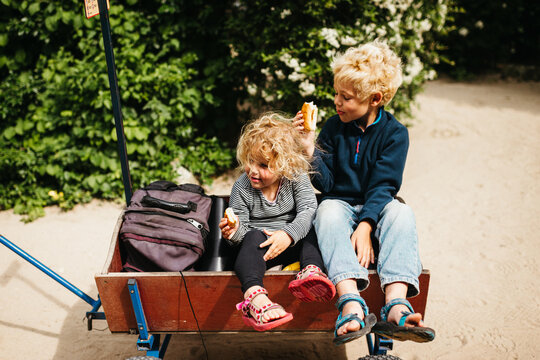 Siblings in a handcart outdoors