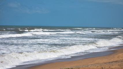 Beautiful bright sea with waves splashing and beach sand of Bay of Bengal at Odisha, Puri