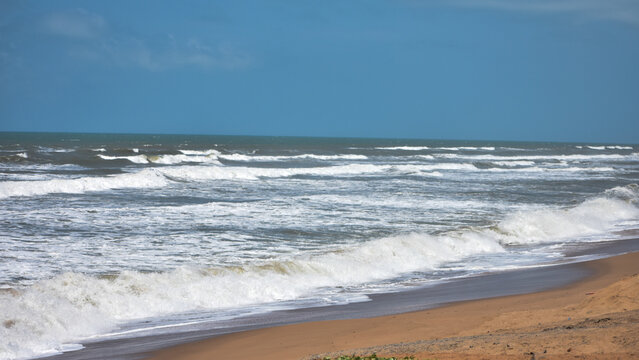 Beautiful bright sea with waves splashing and beach sand of Bay of Bengal at Odisha, Puri