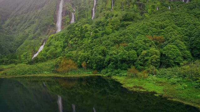 green mountains with waterfalls of Poco Ribeira do Ferreiro, Alagoinha, Flores Island, Azores, Portugal, Europe. Aerial view of amazing natural landscape with cliffs, 4k footage