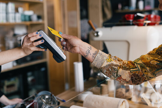 female customer holding credit card near nfc 