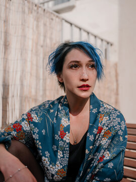 Portrait of a women with blue short hair looking aside
